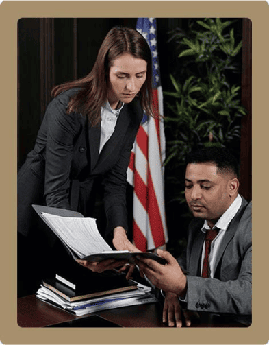 Deux personnes en discussion avec des documents dans un bureau.